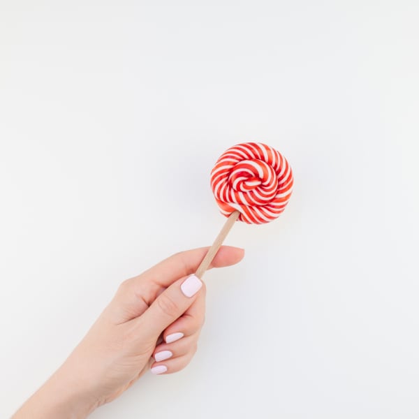 Woman hand with red lollipop