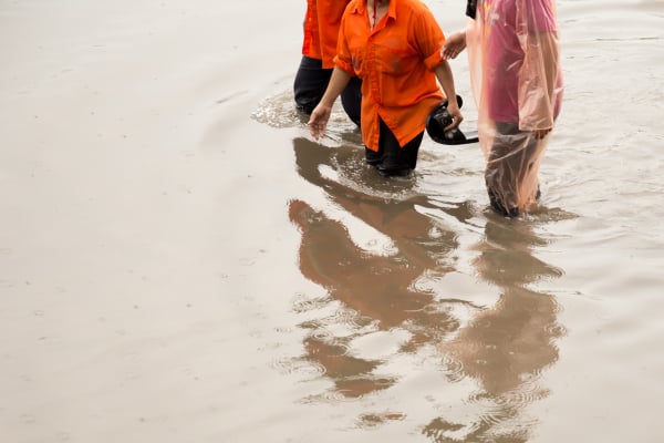asian people walking on flooding road during monsoon season