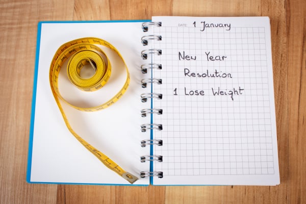 New years resolutions written in notebook and tape measure