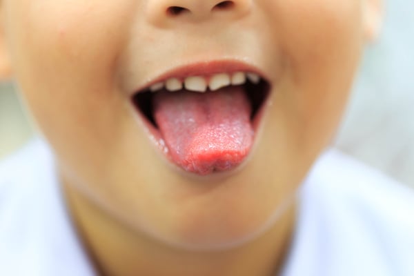 A boy is showing his tongue