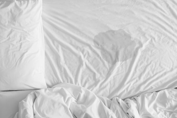 Pee on a bed mattress,Bedwetting sleep enuresis in Adults or baby concept,selected focus at wet on the bed sheet