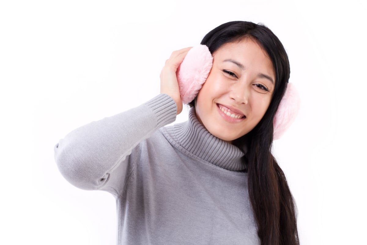 happy, smiling asian-caucasian woman with earmuffs