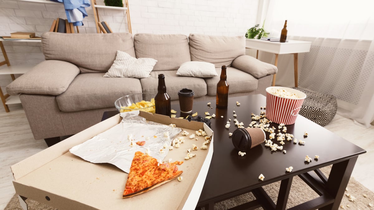 After party interior chaos. Beer bottles, popcorn and pizza