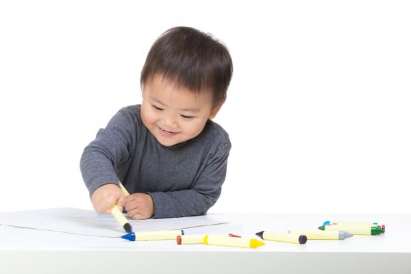 Asian boy drawing with crayon